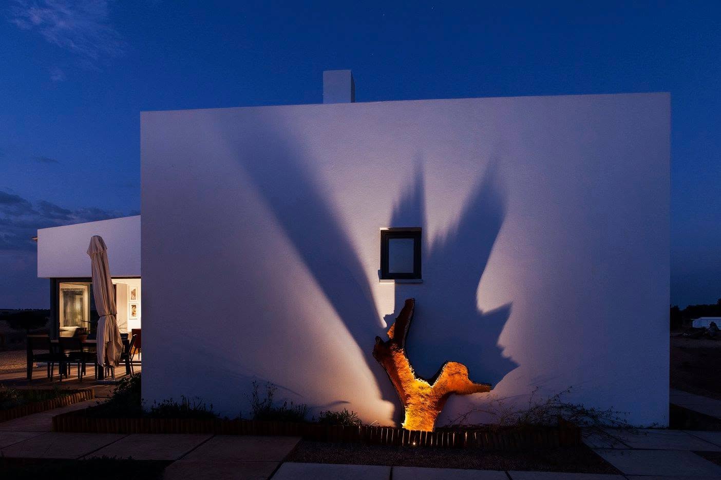 Fachada ao anoitecer com escultura iluminada